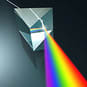 A beam of light that falls through a glass triangle and is scattered in its individual color spectra.